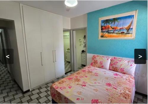 a bedroom with a bed and a painting on the wall at Apartamento em Maceio, uma quadra da praia in Maceió
