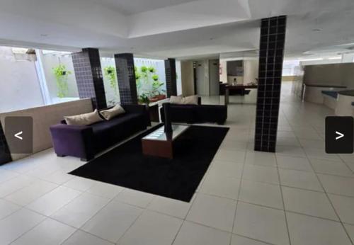 a living room with a couch and a table in it at Quartos em Maceio à 100m da praia in Maceió