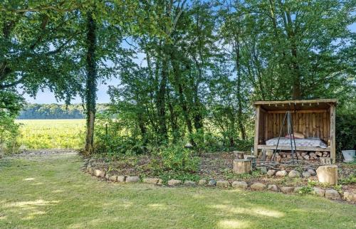 a wooden bed in a field with trees at Large Holiday Home With Pool On South Lolland Coast in Dannemare