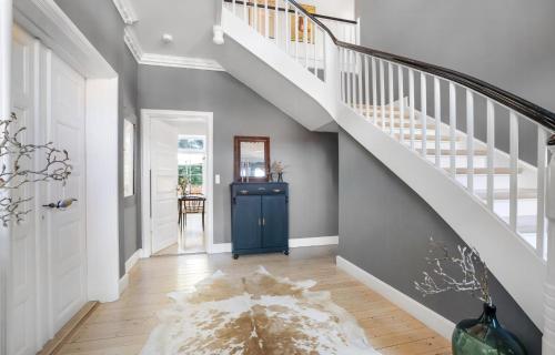 a hallway with a blue door and stairs with a rug at Large Holiday Home With Pool On South Lolland Coast in Dannemare