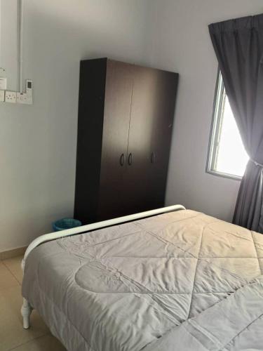 a bedroom with a bed with a dresser and a window at Sal Homestay in Slim River