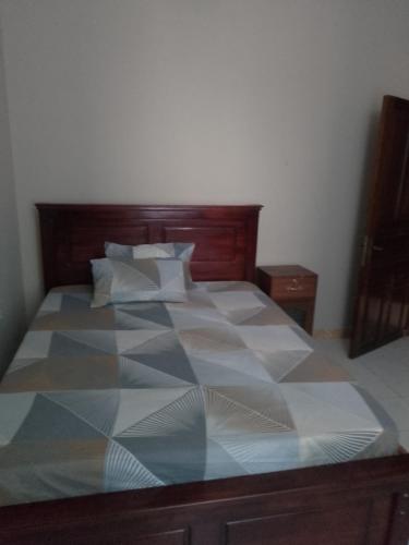 a bedroom with a large bed with a wooden headboard at miss tatu housings in Zanzibar City