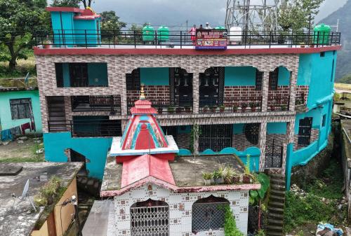 a building with a red tower on top of it at maa kalishila home stay in Ukhimath