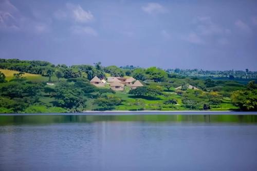 a view of a house from across a lake at Muhazi Flowers Beach & Resorts in Rwamagana