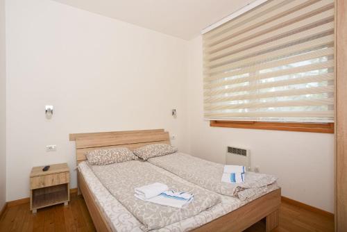 a bedroom with a bed and a window with towels on it at Vila Mina in Zlatibor