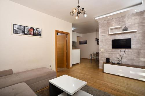 a living room with a couch and a tv on a wall at Vila Mina in Zlatibor