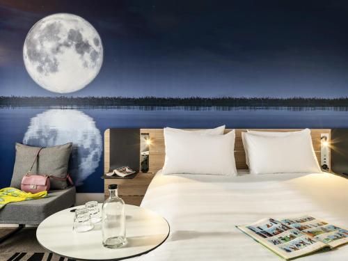 a bedroom with a large bed and a full moon at Novotel Marne-la-Vallée Noisy-le-Grand in Noisy-le-Grand