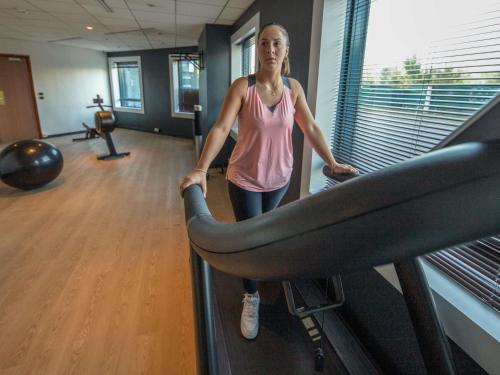a woman walking on a treadmill in a gym at Novotel Marne-la-Vallée Noisy-le-Grand in Noisy-le-Grand