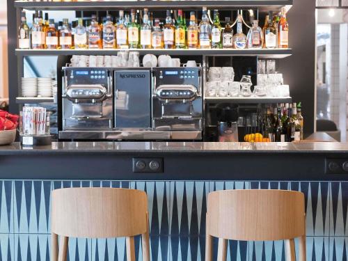 two chairs sitting at a bar with a counter at Novotel Marne-la-Vallée Noisy-le-Grand in Noisy-le-Grand