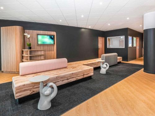 a waiting room with a couch and a table at Novotel Marne-la-Vallée Noisy-le-Grand in Noisy-le-Grand