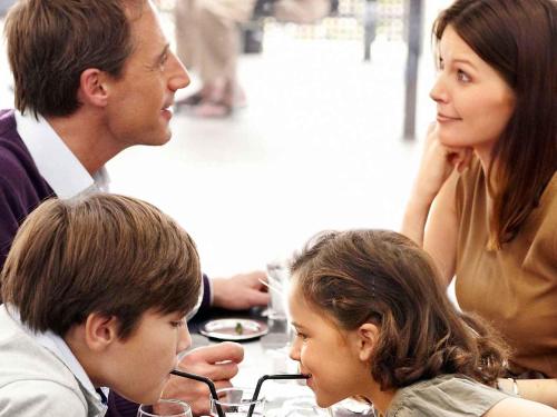 a man and a woman and two children sitting at a table at Novotel Marne-la-Vallée Noisy-le-Grand in Noisy-le-Grand