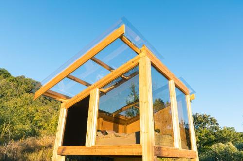 a frame house with glass windows in a field at Wild Orchard Farm in San Costantino Albanese