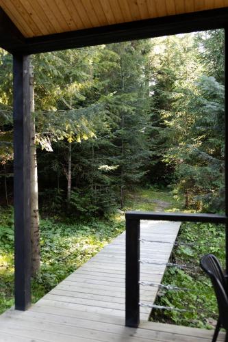 a porch with a wooden boardwalk in the woods at Moho Будинки для відпочинку in Bukovel