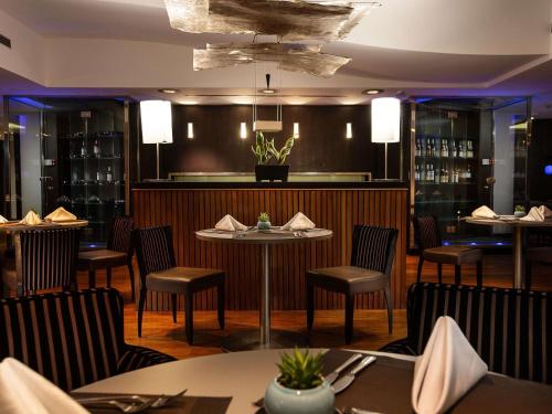 a restaurant with tables and chairs and a bar at Sofitel Algiers Hamma Garden in Alger