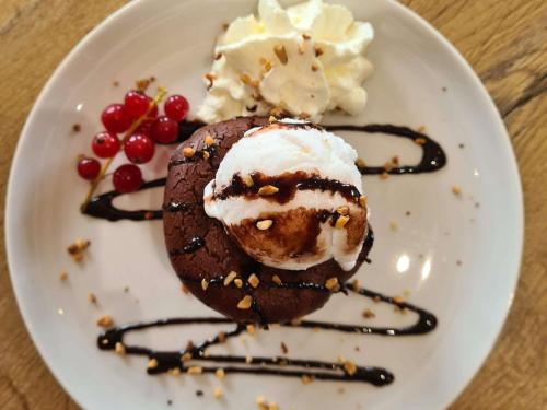 a white plate with a chocolate dessert with ice cream and berries at ibis Vesoul in Vesoul