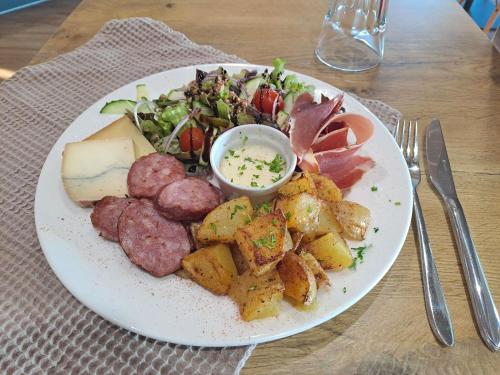 a plate of food with meat potatoes and a salad at ibis Vesoul in Vesoul