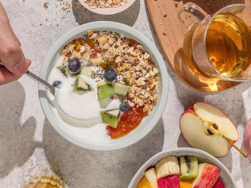 a bowl of cereal with fruit and a bowl of apple slices at ibis Vesoul in Vesoul