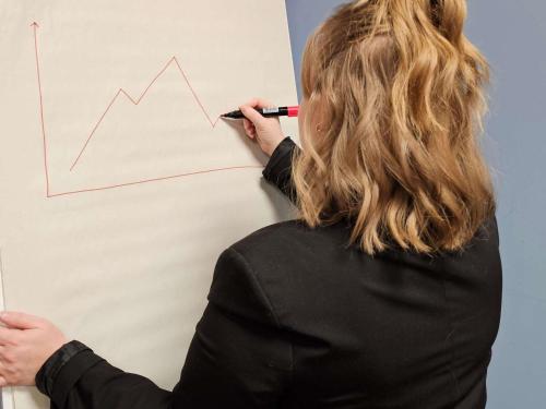 a woman writing on a board with a graph on it at ibis Vesoul in Vesoul