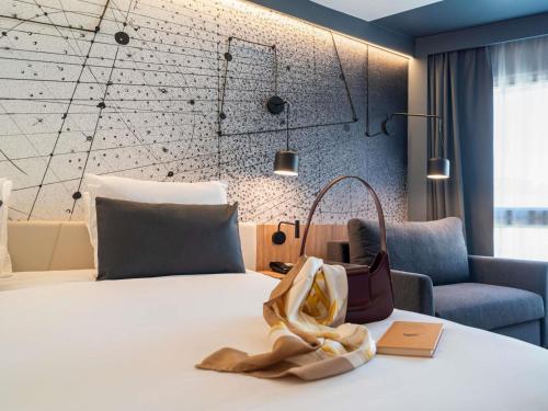a hotel room with a bed with a bag on it at Mercure Montpellier Centre Antigone in Montpellier