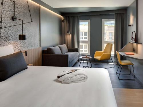 a bedroom with a bed and a living room at Mercure Montpellier Centre Antigone in Montpellier
