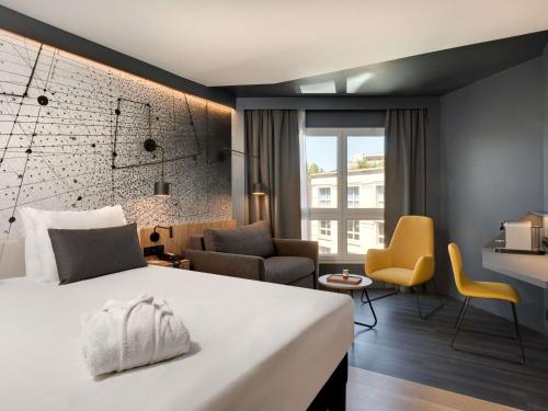 a hotel room with a bed and a living room at Mercure Montpellier Centre Antigone in Montpellier