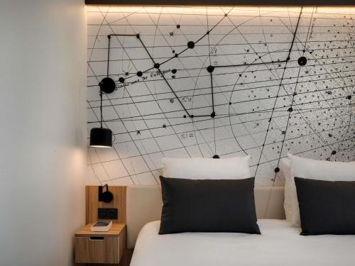 a bedroom with a bed with a wall with music notes at Mercure Montpellier Centre Antigone in Montpellier
