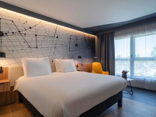 a hotel room with a large bed and a large window at Mercure Montpellier Centre Antigone in Montpellier