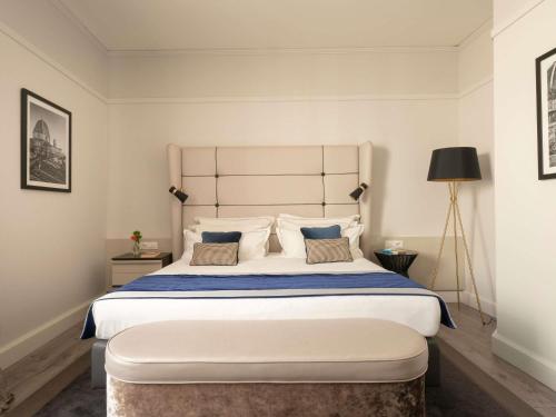 a bedroom with a large bed with two pillows at Cerretani Hotel Firenze - MGallery Collection in Florence