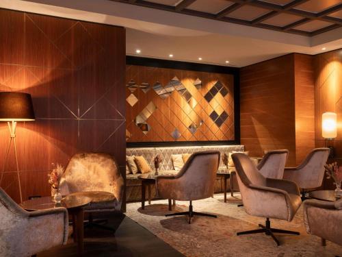 a waiting room with chairs and a table at Cerretani Hotel Firenze - MGallery Collection in Florence