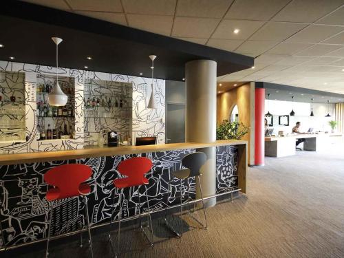 a lobby with a bar with graffiti on the wall at Ibis Marne la Vallée Noisy in Noisy-le-Grand