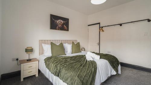 a bedroom with a large bed with a green blanket at Cozy Sheffield Retreat 3BR, 2BA, Parking & WiFi in Sheffield