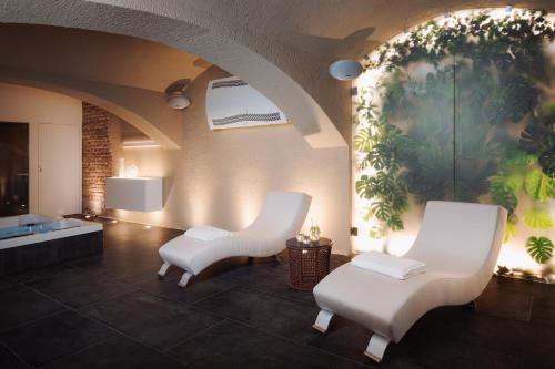 a room with two white chairs and a painting on the wall at EA Hotel Sonata in Prague