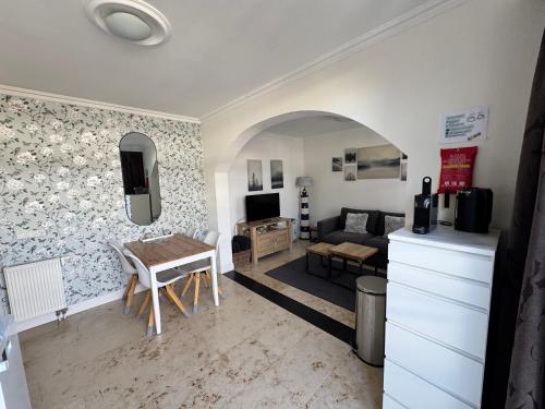 a living room with a table and a couch at Appartement Villa Eva Rosa in Wijk aan Zee