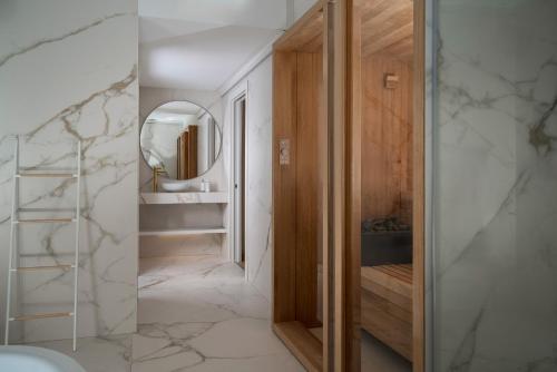 a bathroom with a mirror and a walk in closet at Hotel Regina in Gravedona
