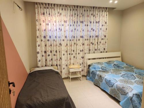 a bedroom with two beds and a curtain at 3BR Furnished Apartment for Rent - PART OF VILLA in Amman