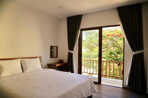 a bedroom with a bed and a large window at Breezy Tuy Hoà Homestay & Coffee in Phước Hậu