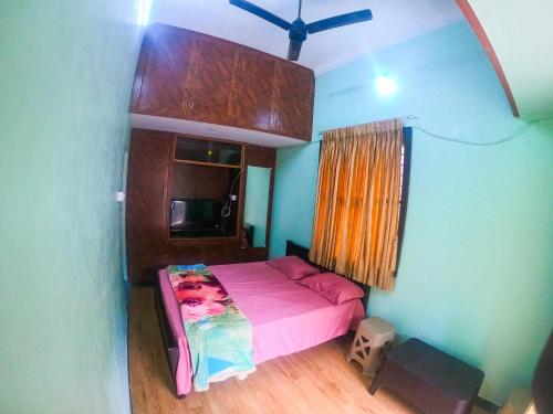 1 dormitorio con 1 cama rosa en una habitación en Kavitha nest, en Yercaud