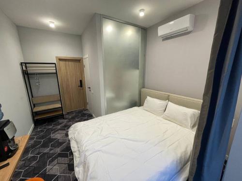 a bedroom with a white bed in a room at Unit Hotel in Almaty