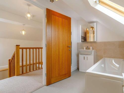 a bathroom with a wooden door and a sink at 4 Bed in Alsop-En-Le-Dale 88935 in Alsop en le Dale