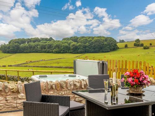 a patio with a table and chairs and a tub at 4 Bed in Alsop-En-Le-Dale 88935 in Alsop en le Dale