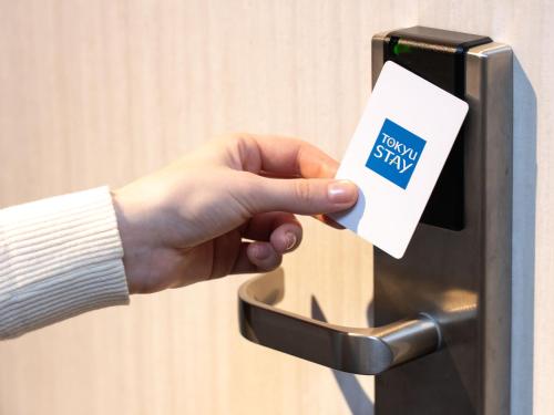 a hand holding a card on a mailbox at Tokyu Stay Aoyama Premier in Tokyo