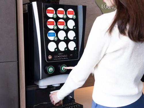 a woman pointing at an ipod in a machine at Tokyu Stay Aoyama Premier in Tokyo