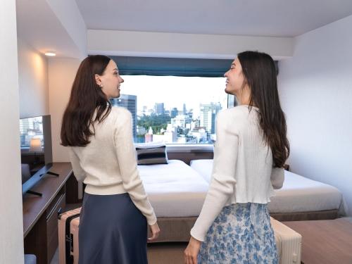 two women are standing in a hotel room at Tokyu Stay Aoyama Premier in Tokyo