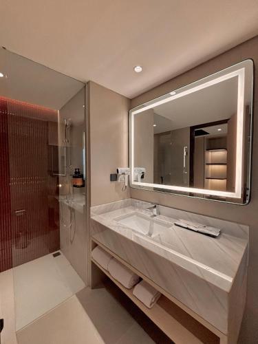 a bathroom with a large sink and a mirror at FortunaSuites Malioboro Yogyakarta in Sentool