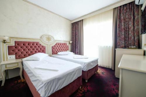 a hotel room with two beds and a window at Hotel Belona in Eforie Nord