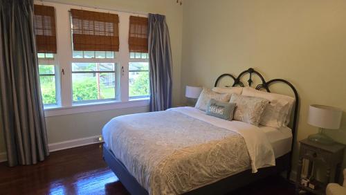 a bedroom with a bed and two windows at The Red Rooster Bungalow in Asheville