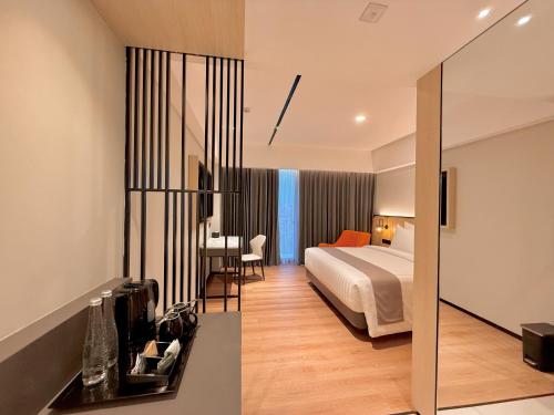 a hotel room with a bed and a desk at FortunaSuites Malioboro Yogyakarta in Sentool