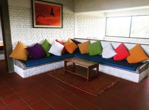 a couch with colorful pillows on it in a room at The Beach House Kalpitiya in Puttalam