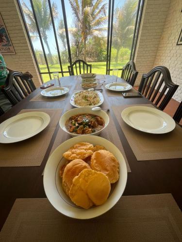 a wooden table with plates of food on it at The Beach House Kalpitiya in Puttalam