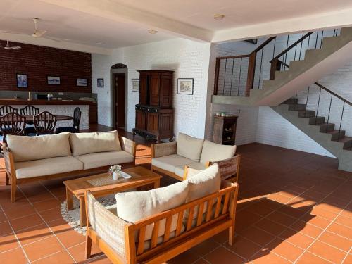 a living room with couches and a staircase at The Beach House Kalpitiya in Puttalam